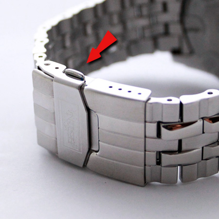 Fermoir déployant fermé d'un bracelet de montre en acier, bouton de libération visible