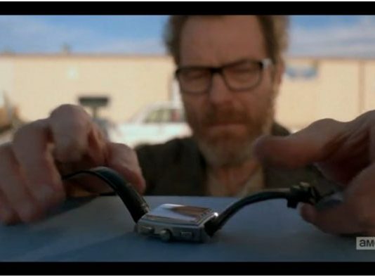 Homme barbu à lunettes détaille une montre Tag Heuer à boîtier carré et bracelet noir