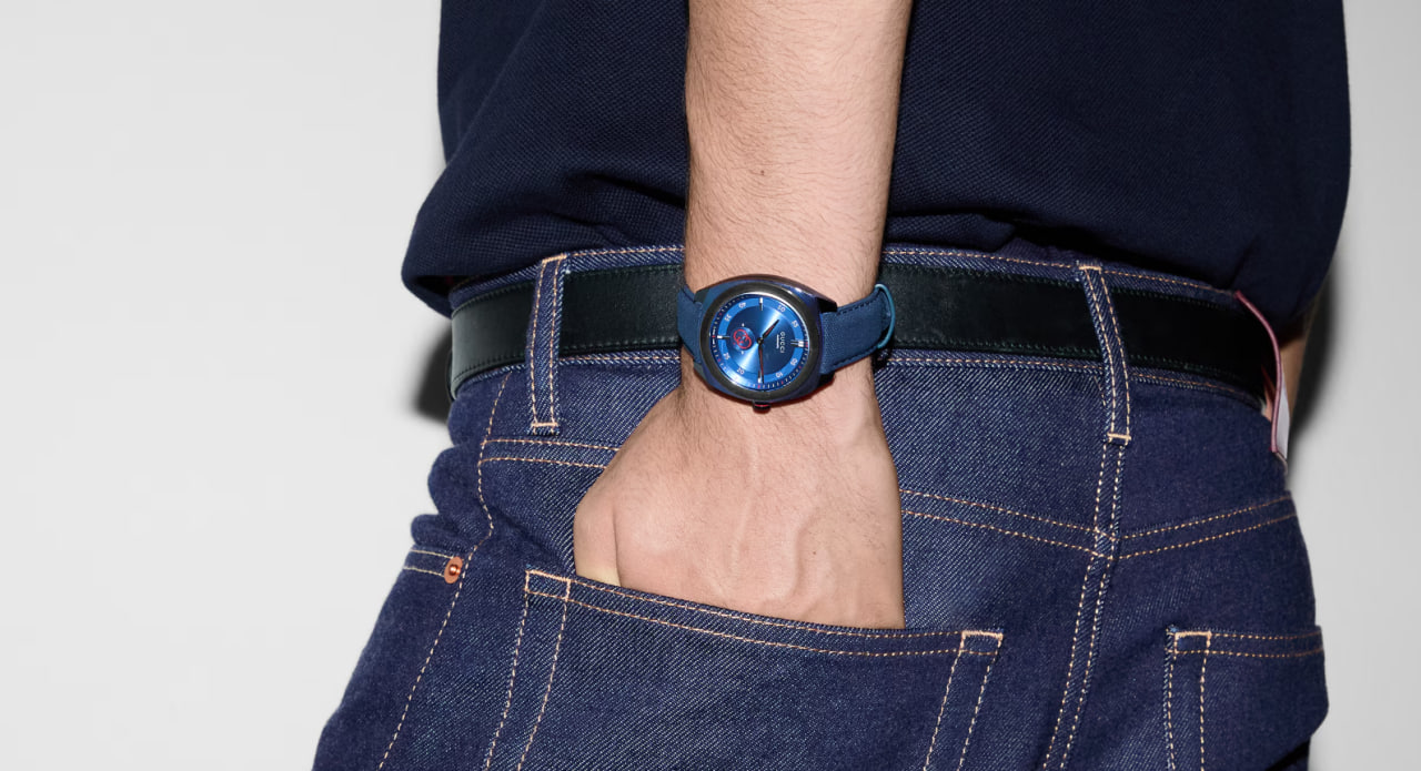 Montre à bracelet Gucci en cuir noir avec détails dorés raffinés.