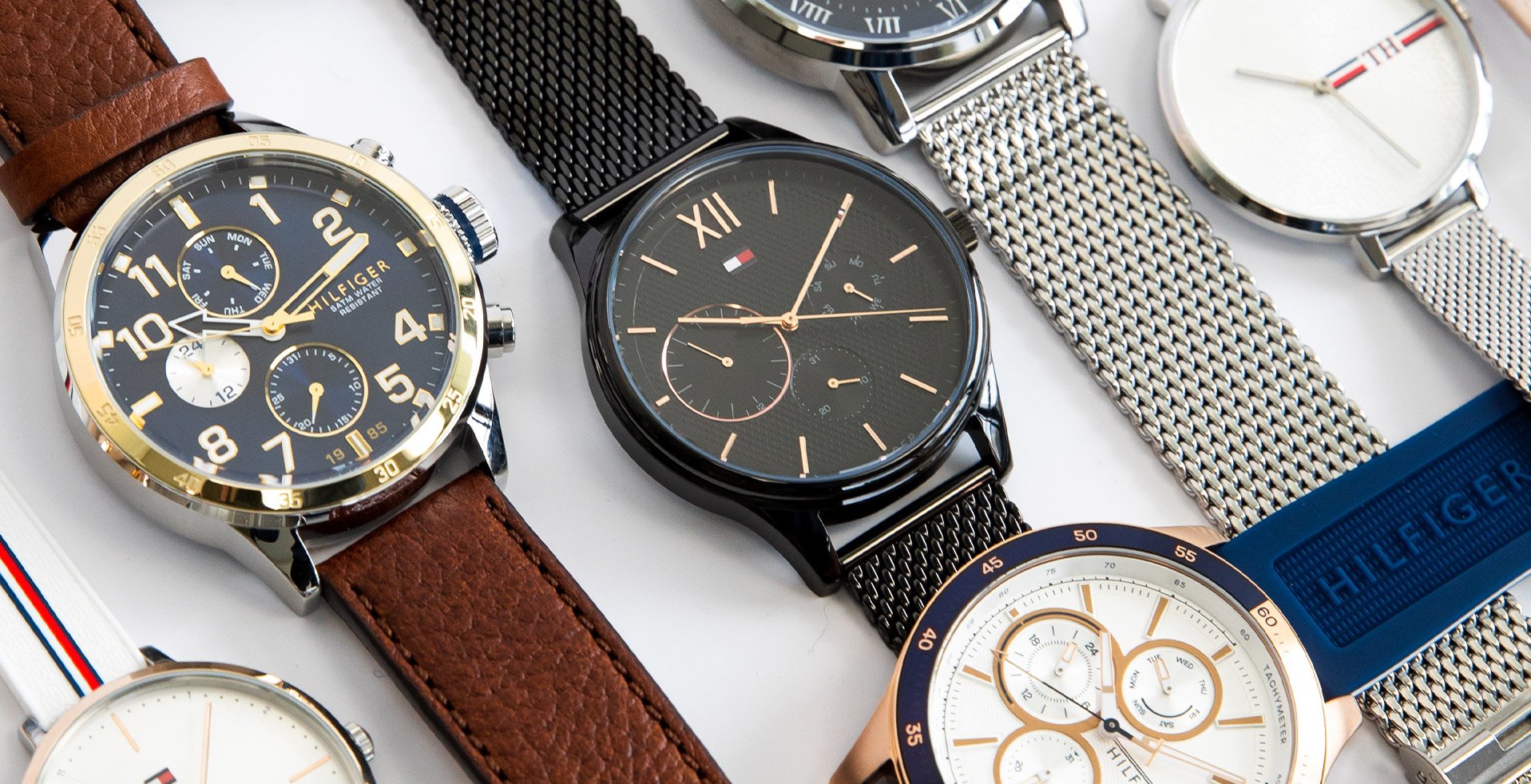 Collection de montres Tommy Hilfiger homme avec bracelets cuir et maille sur fond blanc