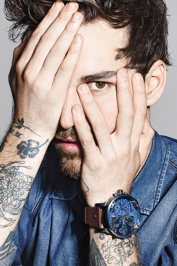 Homme tatoué cachant son visage, portant une <a href=