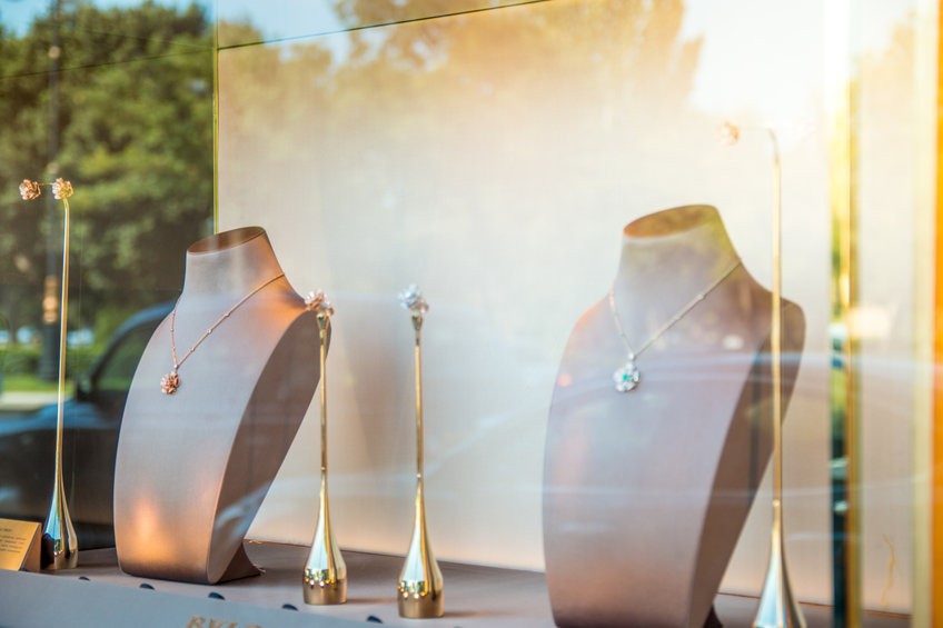 Vitrine de bijouterie présentant des colliers et boucles d'oreilles de luxe sur bustes