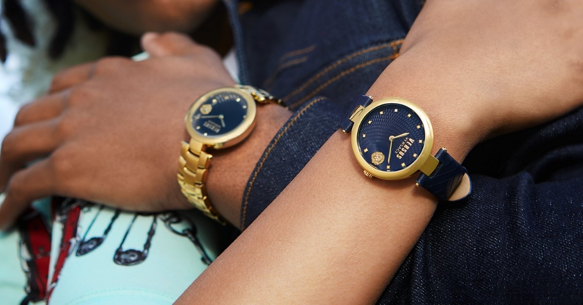 Deux montres femme Versus Versace dorées avec cadrans bleus portées sur des poignets