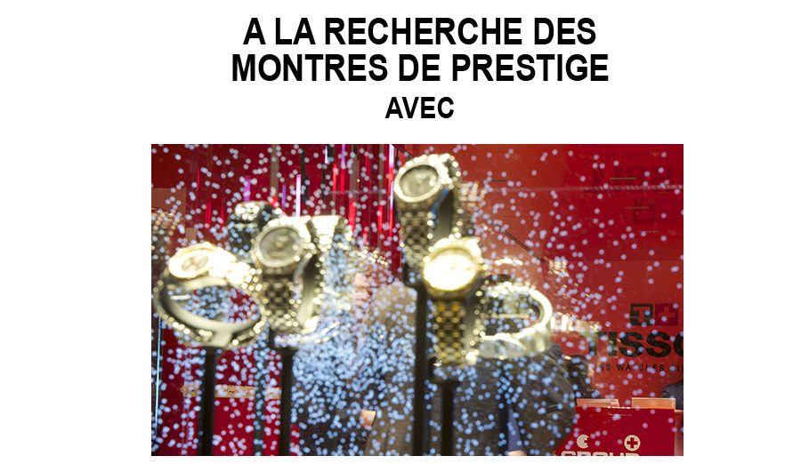 Plusieurs montres de prestige exposées dans une vitrine éclairée avec fond rouge