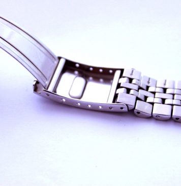 Fermoir de montre à boucle déployante ouvert sur un bracelet métallique brillant