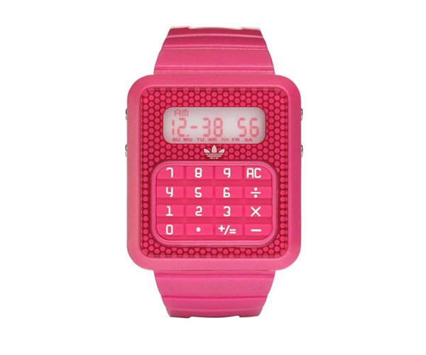 Montre calculatrice digitale rose vif avec écran affichant l'heure et clavier numérique