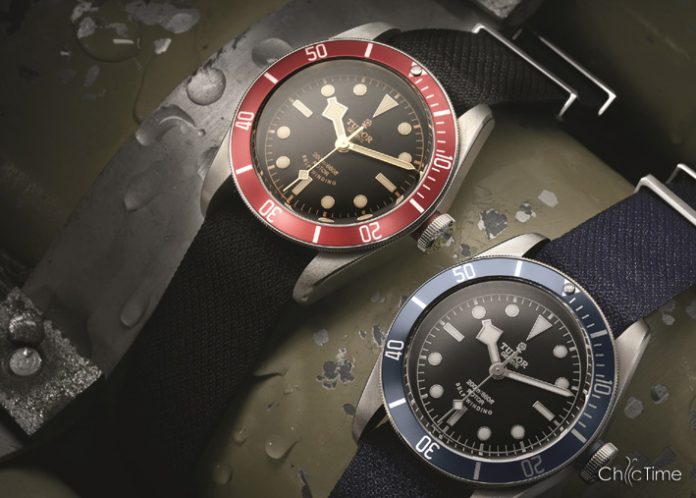 Deux montres avec lunette rouge et bleue, bracelets noirs et bleus, sur fond humide