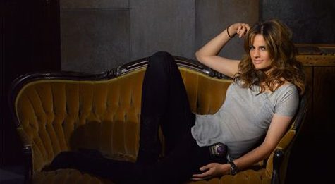 Kate Beckett (Stana Katic) allongée sur canapé vintage avec sa montre Omega